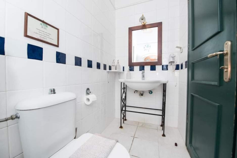 An en-suite bathroom with blue-and-white tiles and a wrought-iron washstand