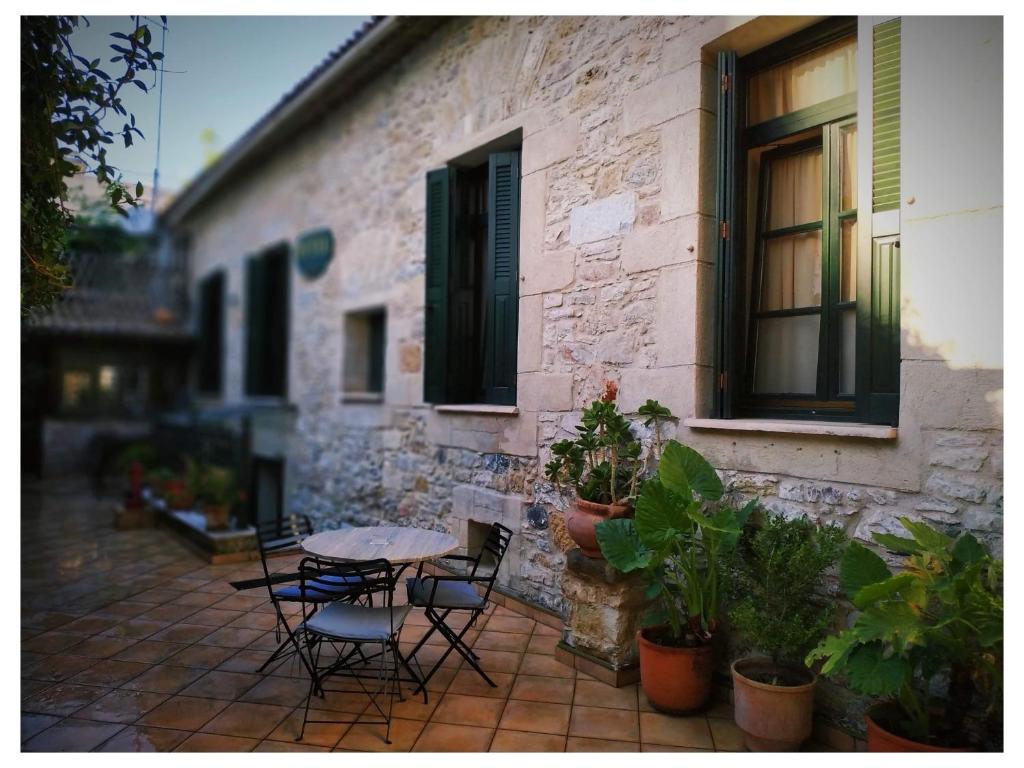 A table set for four against the stone wall and green shutters of the courtyard