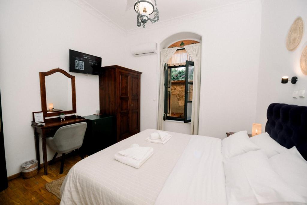A double room with an arched window and green shutters looking onto the courtyard