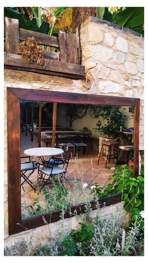 A wooden-framed mirror set into the stone wall, reflecting the courtyard tables